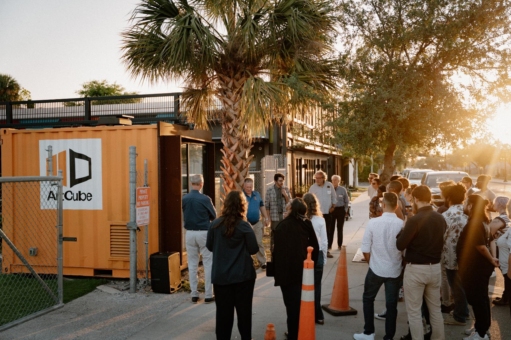 Happy hour crowd gathered around the ArtCube at sunset