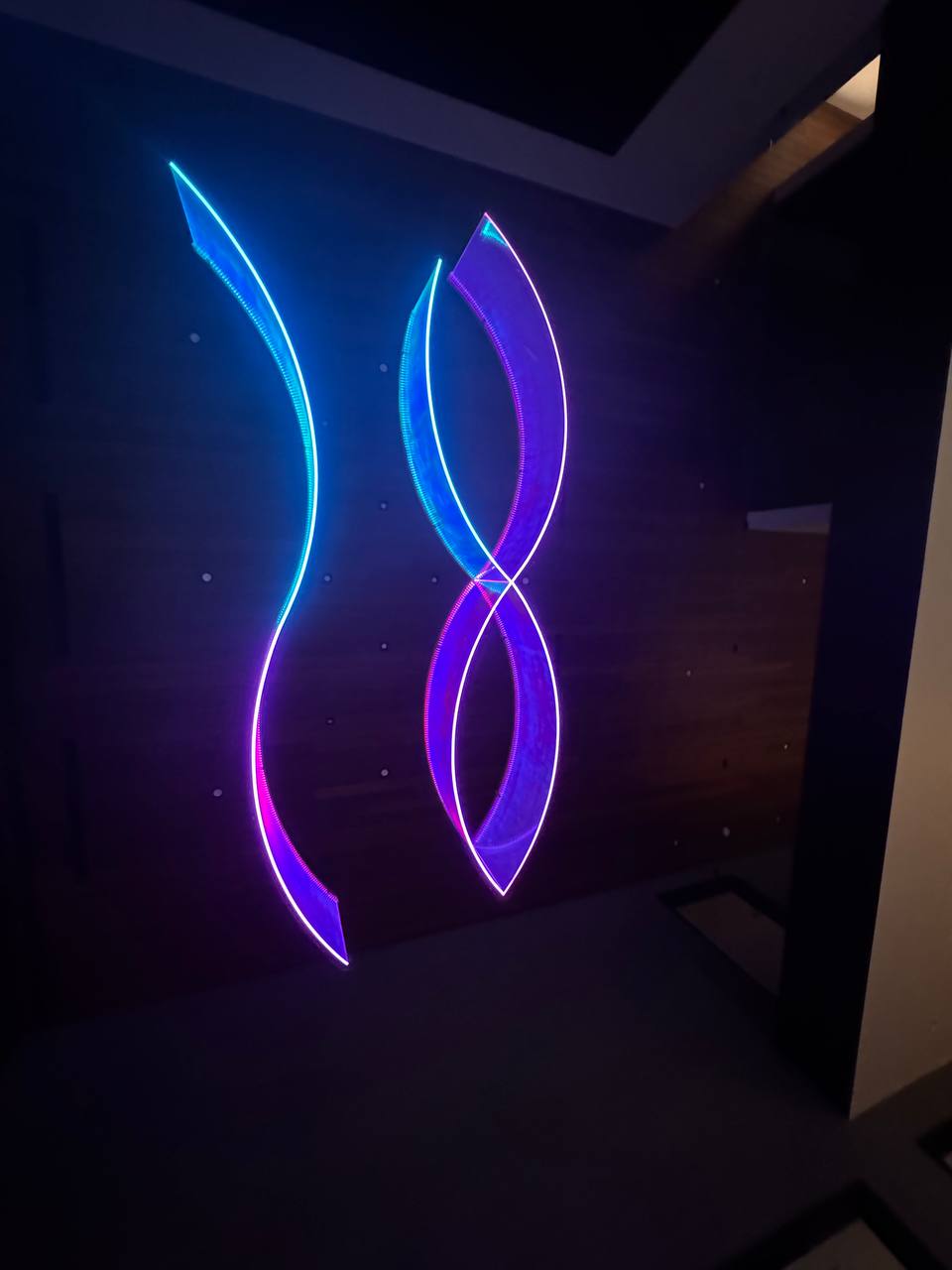 Wall-mounted pieces glowing blue and purple