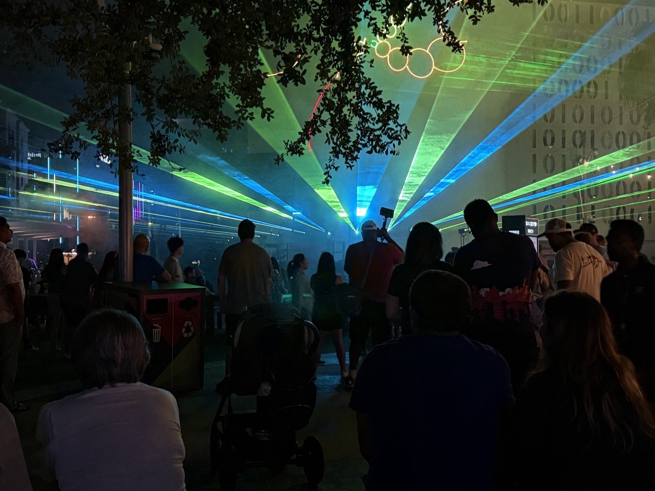 Green and blue lasers with graphic rings projected on the Beacon — families watching